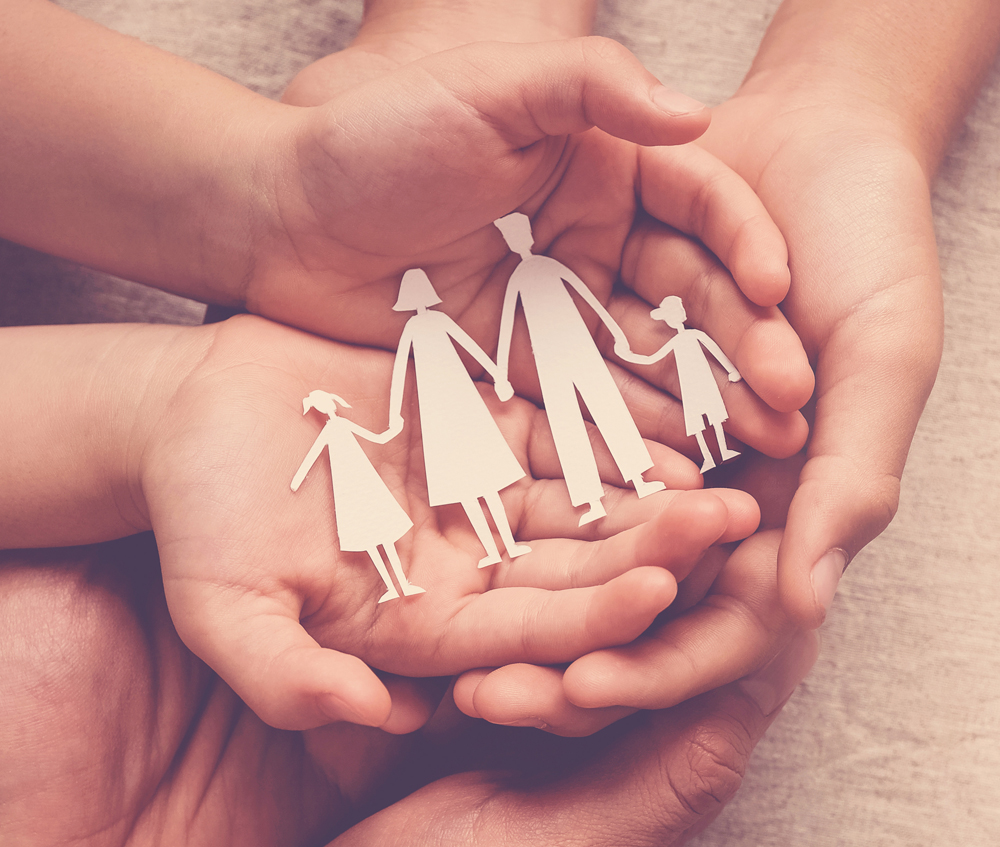 Guardianship - hands holding paper family